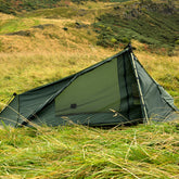 DD Superlight Tarp Tent set up in a grassy landscape, ideal for light travel and minimal backpacking.